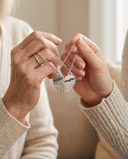 Mother and daughter each holding one half of the split heart necklace