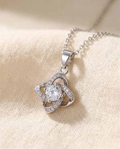 Close-up of the silver-tone knot pendant and its clear center stone