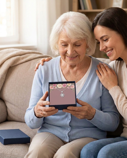 Grandmother opening the navy gift box with her adult granddaughter